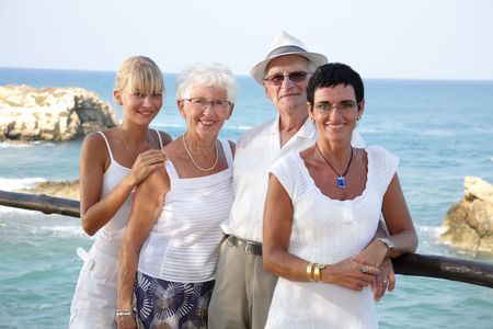 happy family of four standing outdoors (focus on grandparents)の写真素材