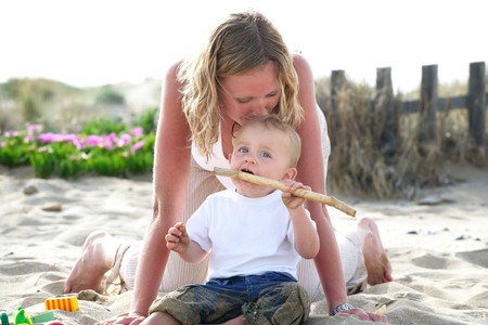 young mother with baby outdoors - bright family lifestyle portraitの写真素材