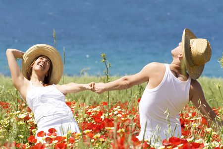 Happy young couple enjoying themselves on a meadowの写真素材