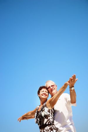 Mature couple on blue sky backgroundの写真素材