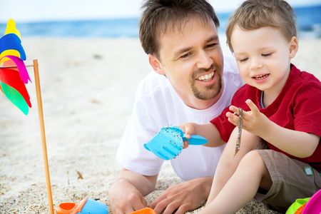 Father and son having fun on the beach.の写真素材