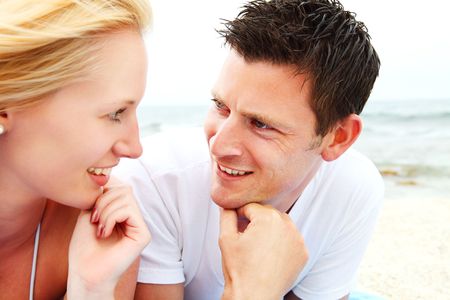 Happy couple on the beach. Shallow DoF with focus on the man.の写真素材