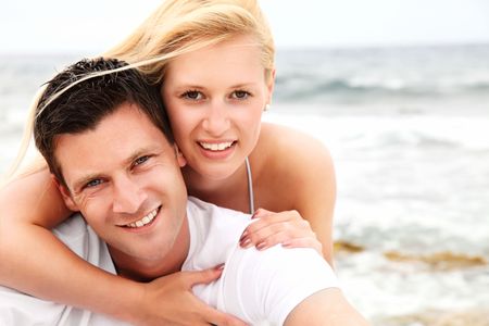 Happy couple on the beach. Shallow DoF with focus on the man.の写真素材