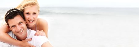 Happy couple on the beach. Shallow DoF with focus on the man.の写真素材