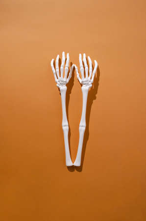 Halloween creative concept. Scary hand bones on orange background.の写真素材