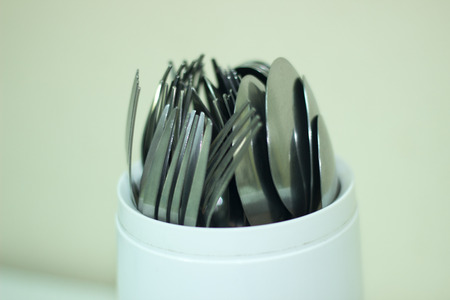 Spoons and forks in a plastic bottle