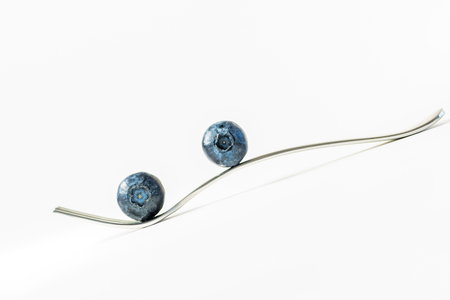 Blueberries on a fork with white backgroundの写真素材