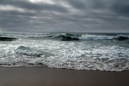 Dramatic seascape, big waves and grey sky, overcast dayの写真素材