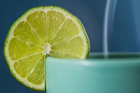 Slice of lime on a tea cup, close up, blue backgroundの写真素材