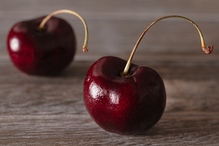 Cherries isolated, wooden background, close up
