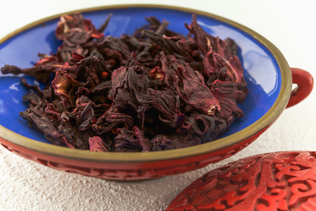 Red hibiscus tea in a bowl on a kitchen table, close upの写真素材