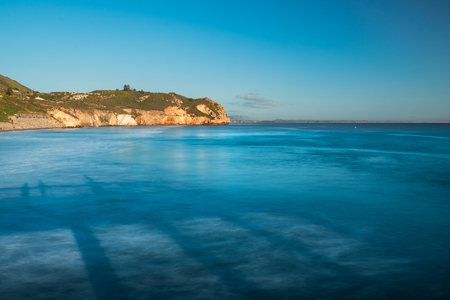 Cliff in the Ocean, Turquoise Colored Water With Reflection From The Pier,  and Clear Blue Skyの写真素材