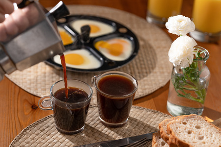 Breakfast. Coffee, Orange Juice, Eggs, Bread on a Kitchen Table, Still Lifeの写真素材