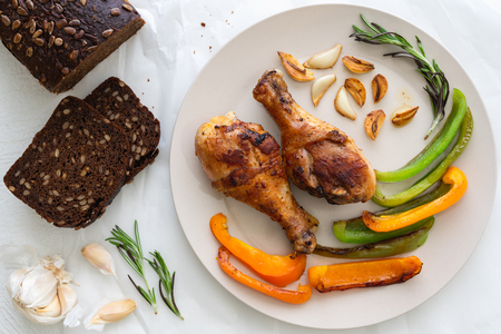 Fried Chicken, Roasted Paprika, Roasted Garlic and Rosemary on a Plate Top View Close Up on White Backgroundの写真素材