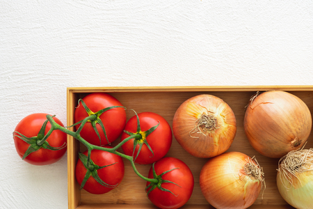 Fresh Red Tomatoes and Onions, Wooden Container, White Background, Close Up, Top Viewの写真素材
