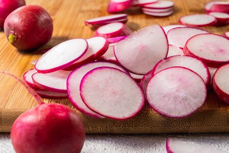 Radish Sliced on a Wooden Chopping Board Close Upの写真素材