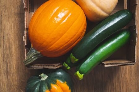 Pumpkin, acorn squash, butternut squash, and zucchini close up , wooden background, top view. Squash family, or cucurbits. Autumn harvest, organic vegetables, healthy lifestileの写真素材