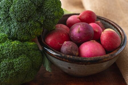 Radish and Broccoli close up on a wooden rustic backgroundの写真素材