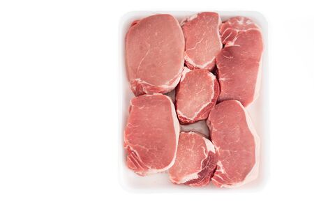 Raw Boneless Pork Loin chops in white plastic container, close up, directly from above, isolated on white backgroundの写真素材