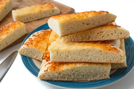 Cheese bread. Homemade delicious  soft cheese bread sticks close up on a plate on white backgroundの写真素材