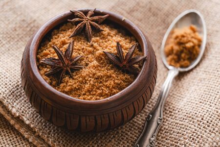 Brown sugar. Close up of wooden bowl with brown sugar and aniseの写真素材