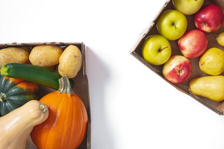 Fruits and Vegetables. Pumpkin, squash, potatoes, zucchini, piers, and apples in container close up, top view, isolated on whie with copy spaceの写真素材