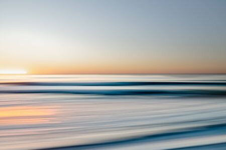 Sunsey over the sea. Abstract seascape. Beautiful blue sea waves, and sun reflection. Abstract background, line art, blur motion effectの写真素材