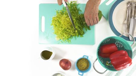 Romaine lettuce on a cutting board. Vegetable salad preparation process.  Fresh organic romaine lettuce, red pepper, onion, some seasoning, and olive oil.の写真素材