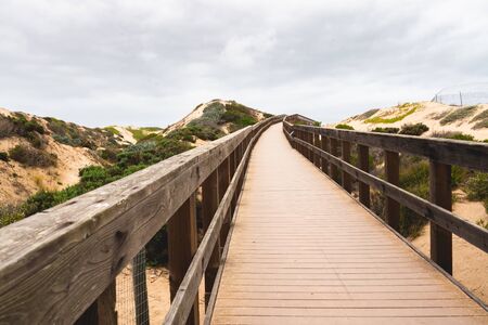 Rustic Wood Beach Boardwalk Through Sand Dunes. Oso Flaco Lake Natural Area State Park, Californiaの写真素材