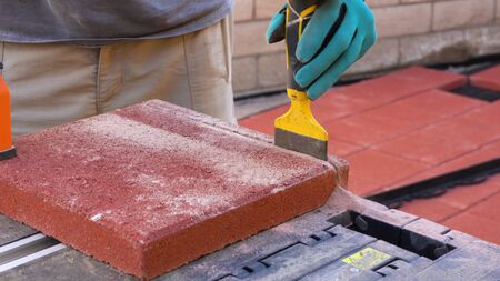 Tile cutter industry equipment. Worker cutting paving tiles for laying on the terrace using circular saw electricの写真素材