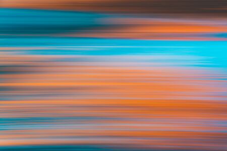 Colorful abstract background. Blue, turquoise, and orange colors. Motion blur, water surface, reflection, line artの写真素材