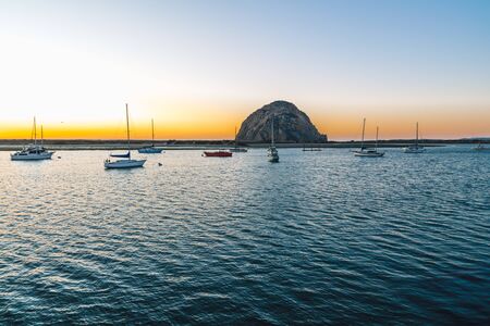 Morro Rock and fishing boats at sunset. Morro Bay harbor, California Coastlineの写真素材