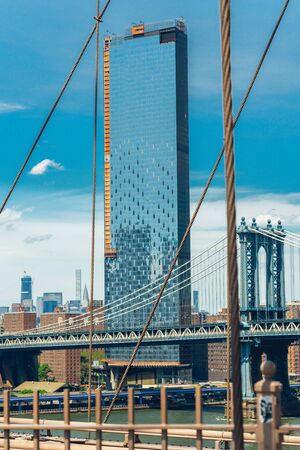 Manhattan bridge, NYC. View from Brooklyn bridge. Manhattan skyline, and beautiful blue sky backgroundの写真素材
