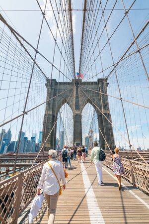 New York City/USA - May 26, 2019  . Pedestrian path across Brooklyn Bridge. Walking people, and Manhattan downtown with skyscrapers over East River on background.のeditorial素材