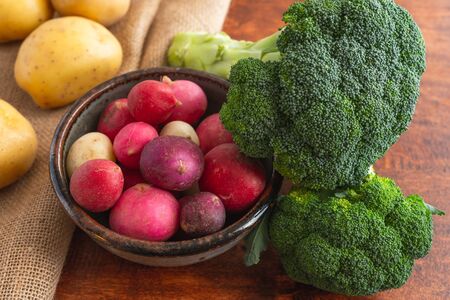 Radish, broccoli and potatoes close up on a wooden rustic backgroundの写真素材