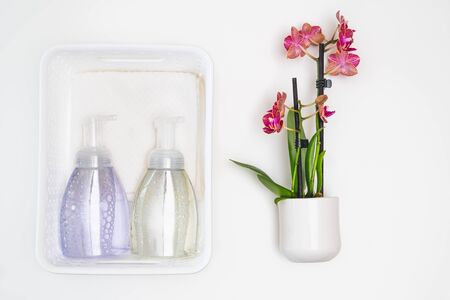 Soap, white cotton towels and Orchid flower close up on white backgroundの写真素材