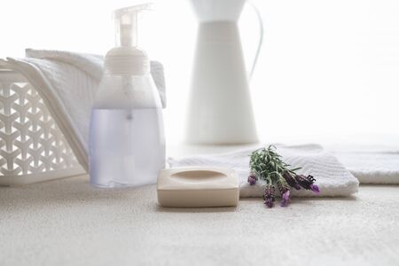 White cotton towels, soap, and lavender flowers on white background, copy space for product display. Aromatherapy, spa conceptの写真素材