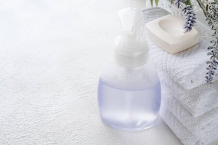 White cotton towels, soap, and lavender flowers on white background, copy space for product display. Aromatherapy, spa conceptの写真素材
