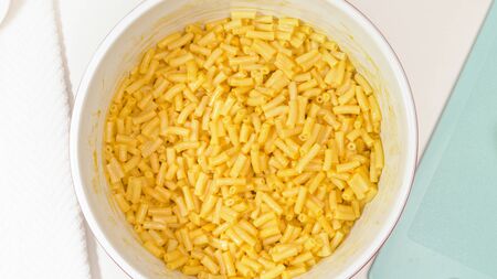 Creamy delicious macaroni and cheese close up in a bowl, view from aboveの写真素材