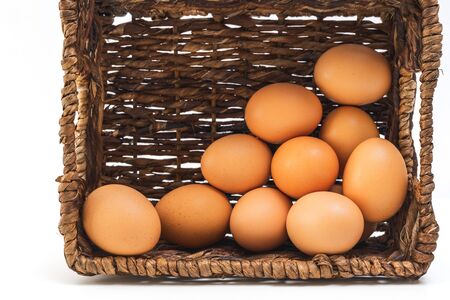 Brown eggs in a basket closeup on white backgroundの写真素材