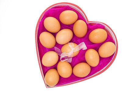 Brown eggs in heart shaped box, close up isolated on white background. Holidays, Easter eggs conceptの写真素材