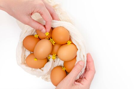 Eggs and flowers. Close up composition on white background, woman hands. Holidays, Easter eggs conceptの写真素材