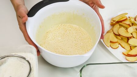 Cake dough in a bowl close up on white background. Step by step Apple pie recipe.の写真素材