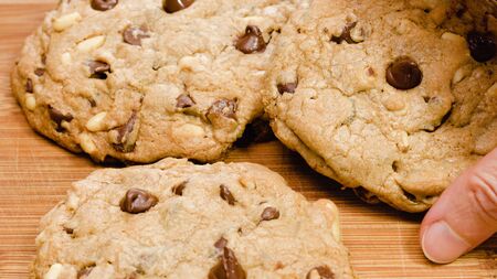 Chocolate Chip Cookies with pine nuts close up on wooden background. Homemade old-fashioned Chocolate Chip Cookies. American cuisine, dessertの写真素材