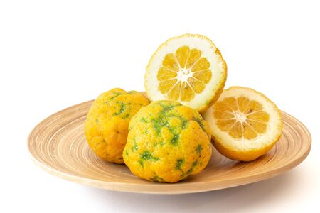 Citrus hybrid close up on a wooden plate, isolated on white backgroundの写真素材