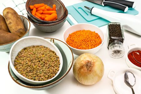 Lentil soup ingredients.  Red lentils, green lentils, onion, carrot, potatoes, and some seasoning close up on white backgroundの写真素材