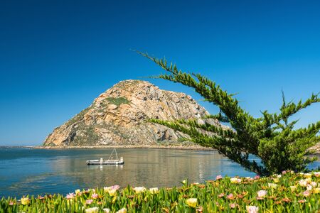 Morro Bay State park, California Coastline. Beautiful Morro Rock, quiet water, and clear blue sky backgroundの写真素材