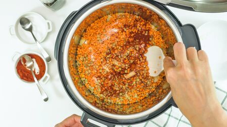 Multi cooker lentil soup recipe. Mixing ingredients, close up view from aboveの写真素材