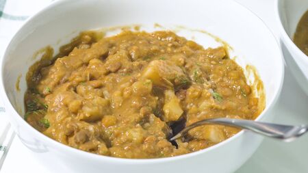Creamy lentil soup in a bowl close up on kitchen tableの写真素材