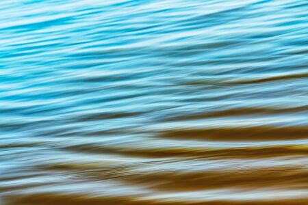 Abstract seascape background, tranquil water pattern. Motion blur, light blue and yellow colorsの写真素材